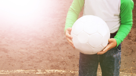 Children's hands holding a soccer ball, sportの写真素材