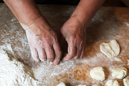 Female hands making dough for pizza, food