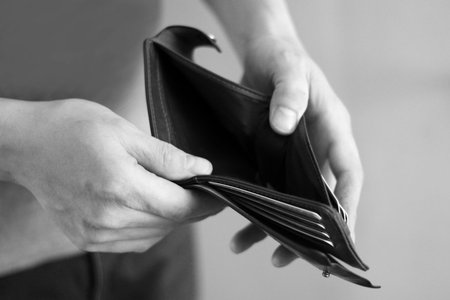 Empty wallet in the hands of an elderly man so close