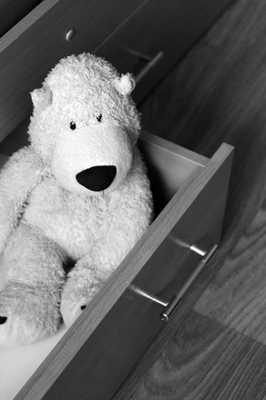 White soft bear in the open drawer of the bedの写真素材
