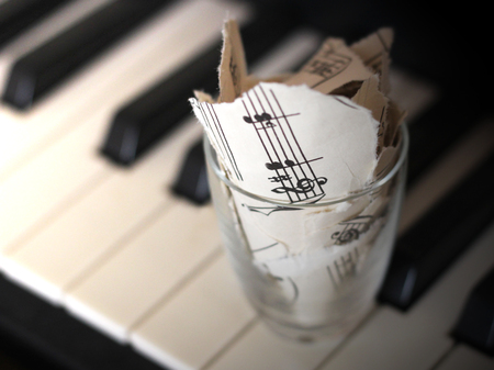 Torn musical notes, pieces of paper on piano so closeの写真素材