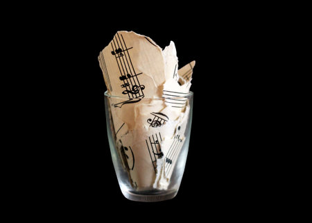 Torn musical notes in a glass, pieces of paper so close