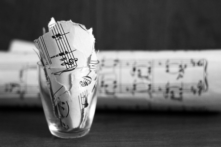 Torn musical notes in a glass, pieces of paper so closeの写真素材