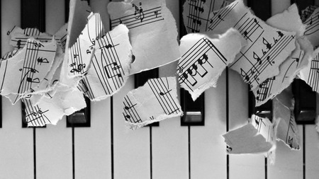 Torn musical notes, pieces of paper on piano so closeの写真素材
