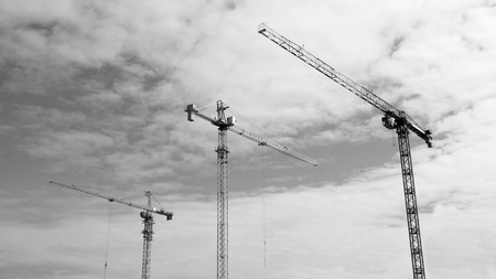 Construction site tower cranes against skyの写真素材