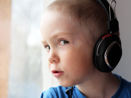 Blond boy in big headphones, a portrait