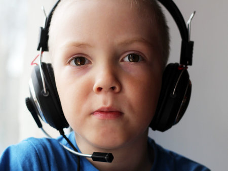 Blond boy in big headphones, a portrait
