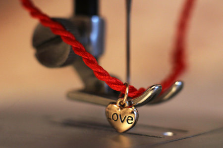 Red string with a heart of gold and a sewing machine so close