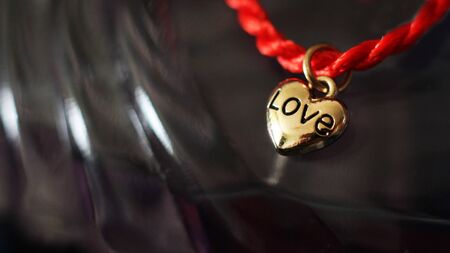 Red thread with gold heart pendant and women's perfume, giftの写真素材