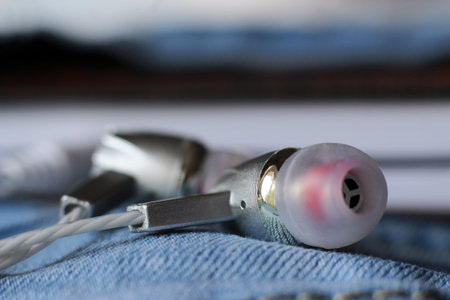Silver headphones on jeans, closeup