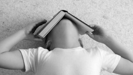 Little boy tired of reading book, school themeの写真素材
