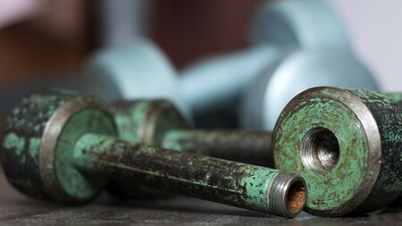 Old iron collapsible dumbbells on the wooden floor so closeの写真素材