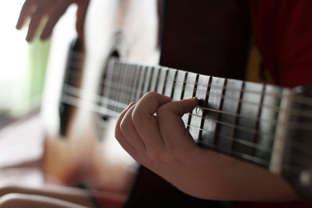 Child playing guitar, learning music, hands so close