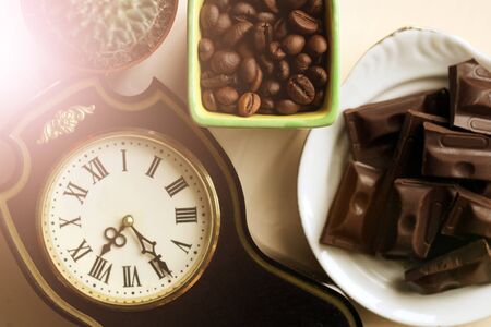 Retro clock with Roman numerals, coffee beans and chocolate, top viewの写真素材