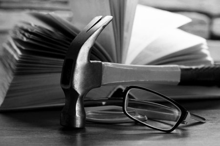 Broken yellow eyeglasses, a hummer and a book so close
