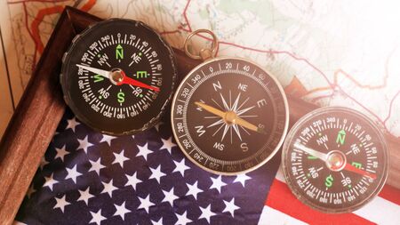 Three compasses and an American flag in a wooden frame, travel themeの写真素材