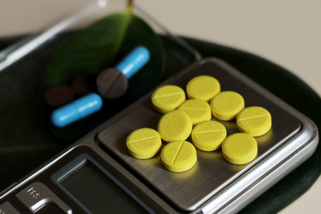 Medical capsules on electronic scales, pharmacist theme so close