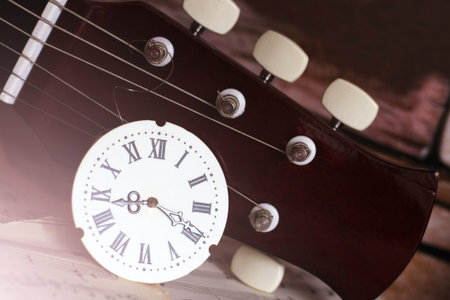 Clock with Roman numerals and guitar, retro composition so close