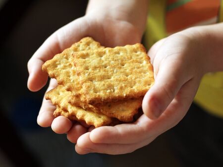 Square cookies in children's hands so closeの写真素材