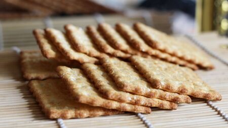 Time to drink tea and coffee break. A lot of square cookies with sesame seeds. A tasty and healthy cracker for a healthy and dietary diet.の写真素材
