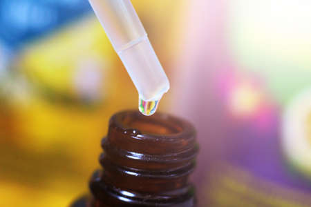 Close-up Dropper with drops Essential liquid so close. Colored background.の写真素材