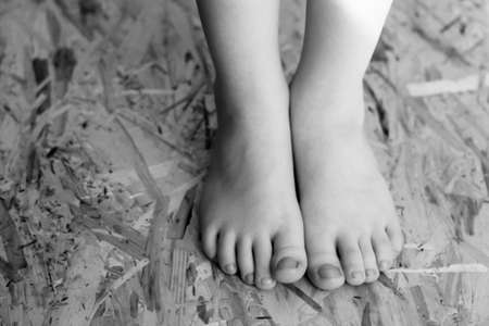 Children's feet on OSB material so closeの写真素材
