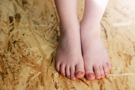 Children's feet on OSB material so close