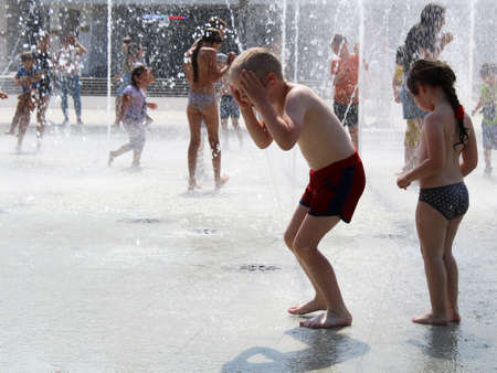 July 15, 2020. Izhevsk, Russia. Happy children playing in water fountains summerのeditorial素材