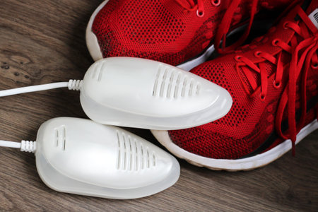 Electric ultraviolet shoe dryer and red sneakers so close