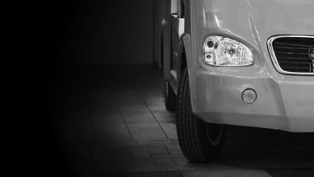 Car's bold front face on a black background. Transport.