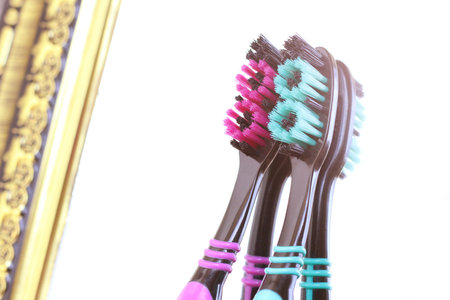 Two colored toothbrushes and a mirror in the bathroom, close upの写真素材