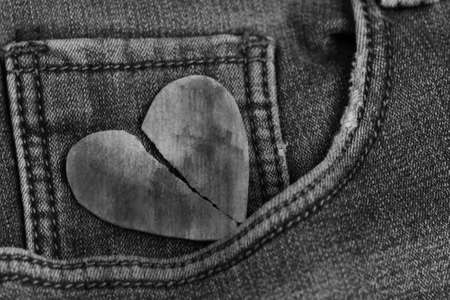 Black heart ripped in half on jeans, top viewの写真素材