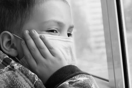 A little boy in a medical mask. Stays at home, self-isolation, Covid 2019. Virus.の写真素材