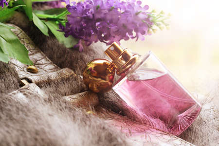 bottle of pink perfume on a fur so closeの写真素材
