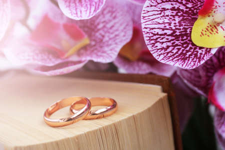 bouquet of pink flowers, wedding rings and a book so closeの写真素材