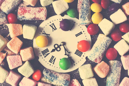 Retro watch with Roman numerals delicious marmalade of different colors, sweet foodの写真素材