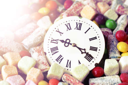 Retro watch with Roman numerals delicious marmalade of different colors, sweet foodの写真素材