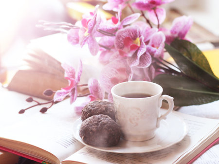 A Cup of coffee at open books and pink orchid, romantic imageの写真素材