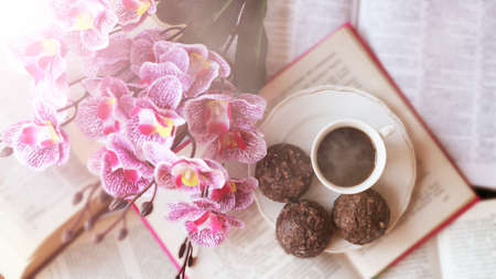 A Cup of coffee at open books and pink orchid, romantic imageの写真素材