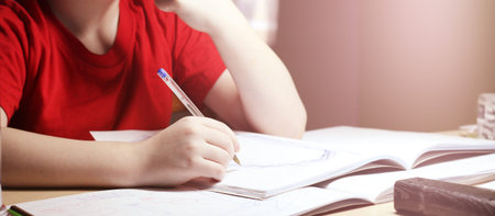Portrait of a young boy writing in the room so close