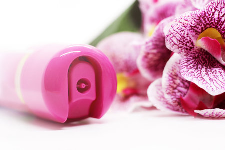Spray air freshener and pink orchid on white background aroma for home