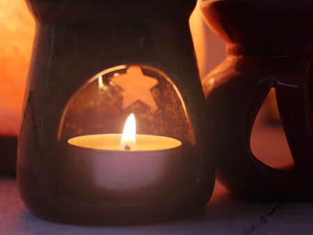 Aromatherapy. Candles and aroma lamp, pleasant relaxation, orange color image.の写真素材