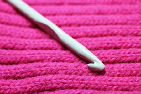 Large crochet hook on pink scarf so closeの写真素材