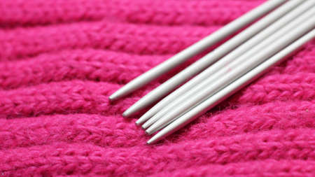 Knitting needles on a pink scarf so closeの写真素材