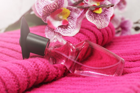 orchid and perfume bottle on a pink scarf so closeの写真素材