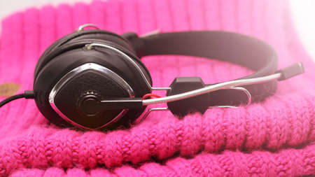 Black elegant headphones on a pink scarf so closeの写真素材
