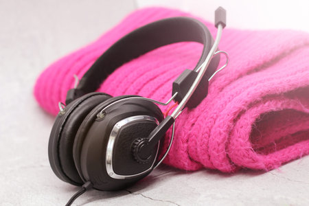 black headphones with pink scarf on a light background, close-up