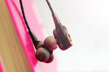 Macro close up of black earphones and a pink book, musicの写真素材