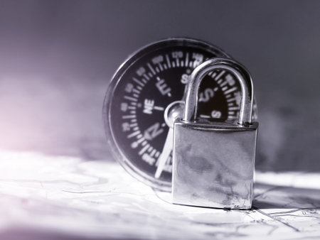 Close up of a padlock on a map with a compass.