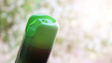 Green bottle on blurred background with bokeh effect.の写真素材